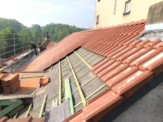 Chantier en cours : pose de tuiles terracotta sur charpente neuve avec tasseaux et sous-toiture DELTA. KToit, region Hainaut. Pose de tuiles terracotta sur charpente neuve avec tasseaux et sous-toiture par KToit, couvreur Morlanwelz