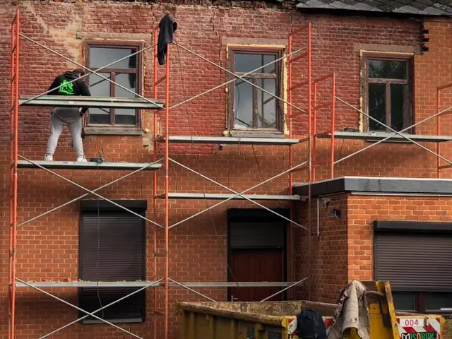 Pose progressive de tuiles terracotta sur charpente avec tasseaux et sous-toiture. Couvreur KToit en action. Pose de tuiles terracotta sur charpente avec tasseaux verts par couvreur KToit, ciel ouvert
